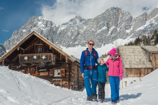 Familie beim Wandern im Winter | Im Hintergrund der Dachsteingletscher